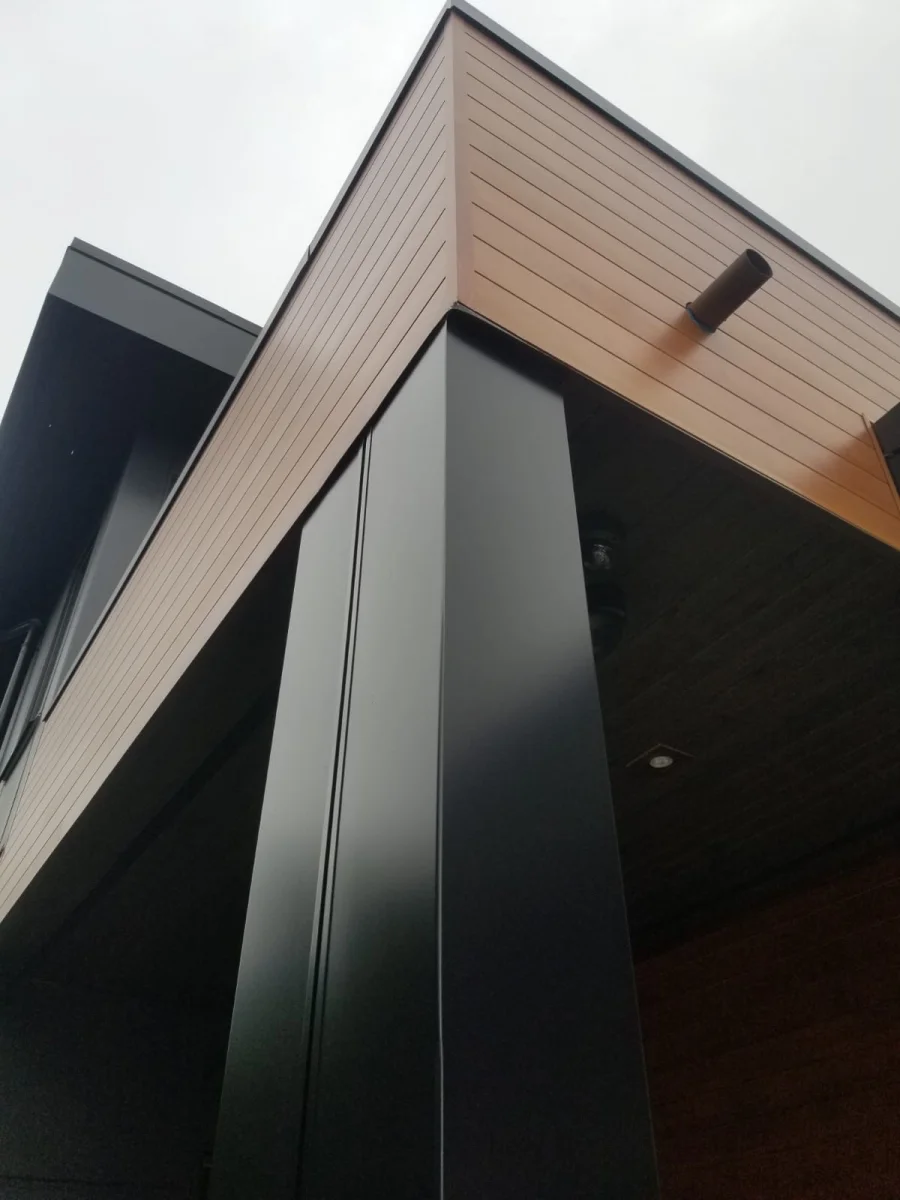 Dark metal cladding panel corner detail with cedar soffit in North Vancouver
